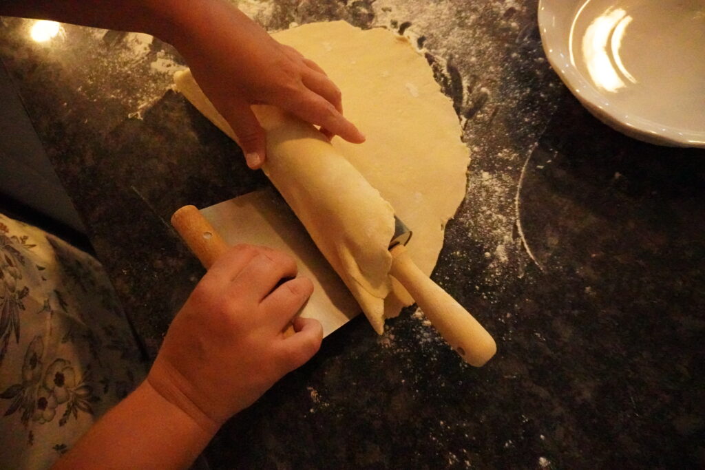 pie dough being rolled onto a rolling pin